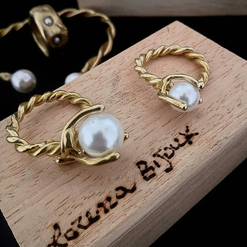 Per mano, Bronzo giallo, Perla bianca